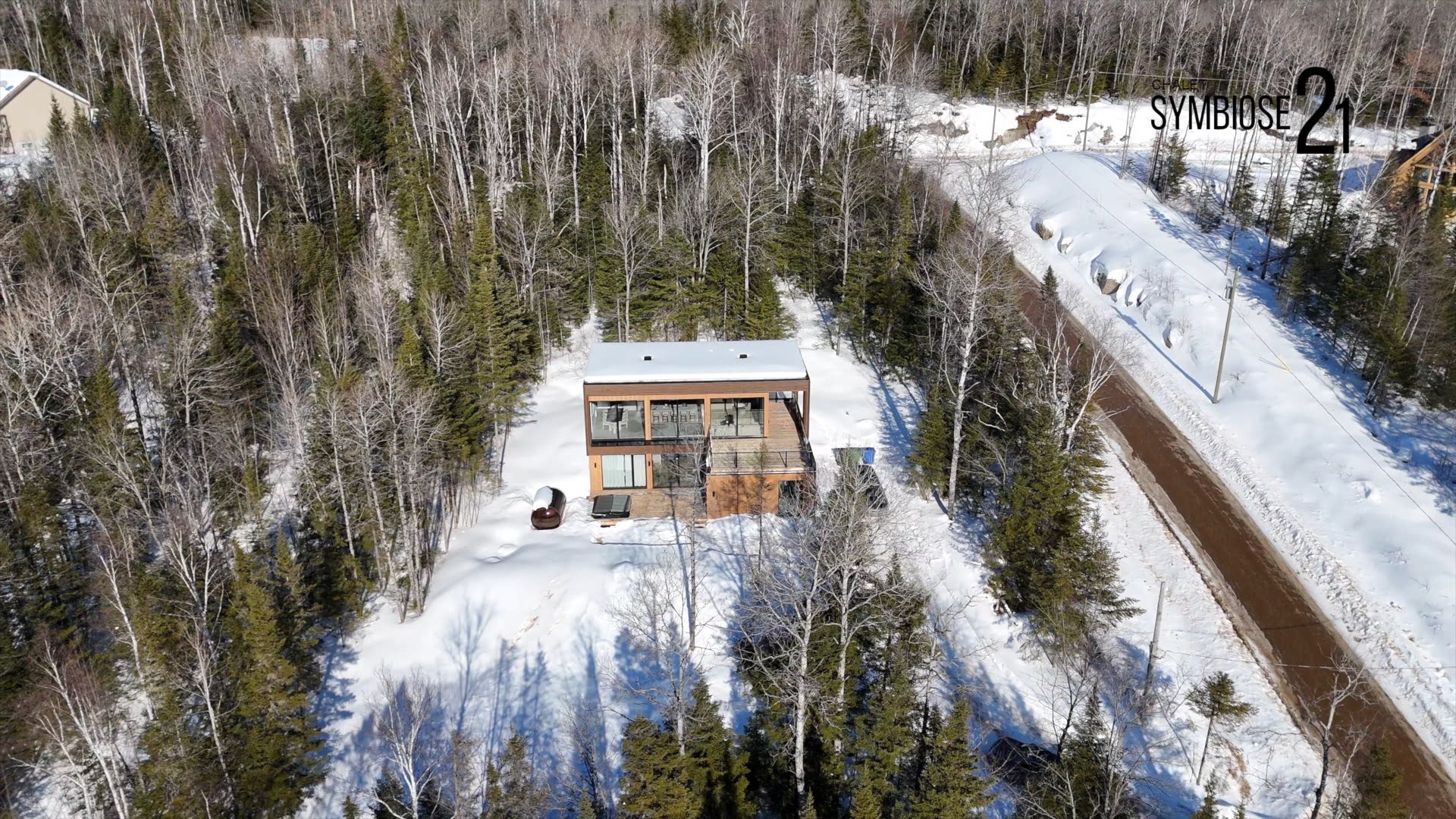 Aerial view of Chalet Symbiose 21 in the snowy Saint-Côme forest